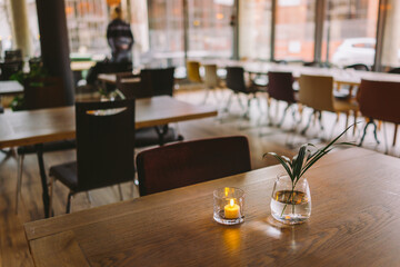 Table setup in a indoor restaurant with dish flowers and lights