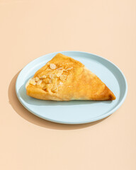 Homemade pancake with almond on blue plate on beige background.