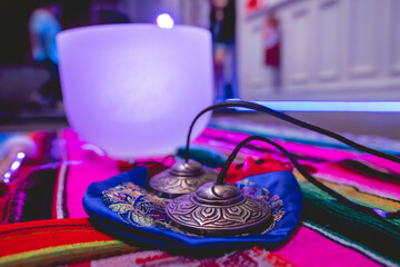 Tingsha cymbals and big quartz singing bowls over a andean (peruvian) handwoven with purple light