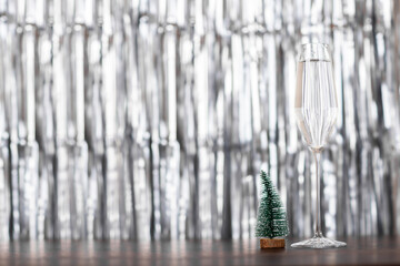 Christmas tree and glass of champagne on silver background with copy space. Merry xmas and Happy new year 2023 background. Winter holiday celebration