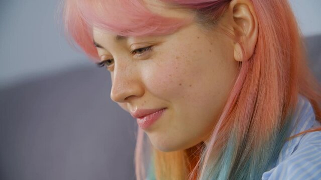 Cheerful Diverse Woman With Rainbow Colored Hair Working On A Computer At Home. Close Up Video Clip Of Young Adult Female From Kyrgyzstan Using A Laptop For Distant Work Online