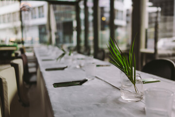 Table setup in a indoor restaurant with dish flowers and lights