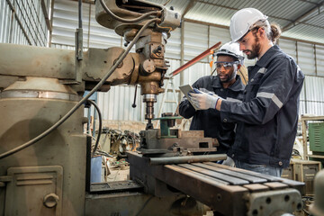 Team of engineers practicing maintenance Taking care and practicing maintenance of old machines in the factory so that they can be used continuously.