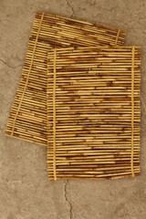 Top shot of Asian bamboo placemats on concrete surface