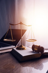 Justice and law concept.Male judge in a courtroom with the gavel, working with, computer and docking keyboard, eyeglasses, on table in morning light