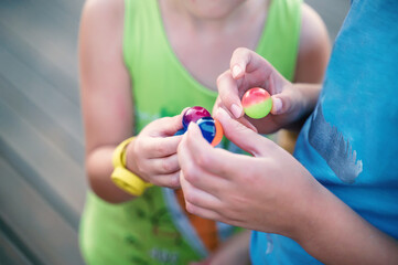 Naklejka premium hands of children playing with small transparent balls. Communication, communication of children of different ages. Soft selective focus