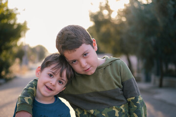 Portrait of two friendly young brothers embracing each other.