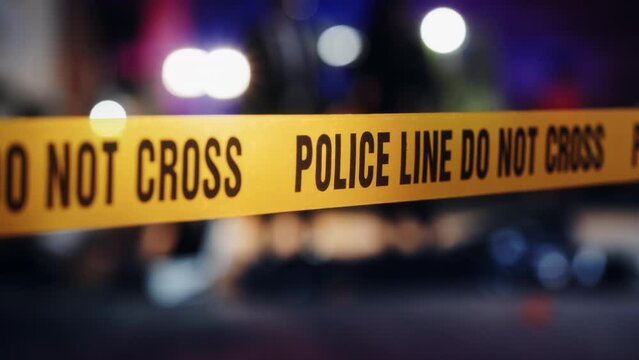 Close Up on Crime Scene Yellow Tape Showing Text "Police Line Do Not Cross". Restricted Area to the Public. Police on Duty in the Background. Cinematic Bokeh Effect With Red and Blue Neon Lights