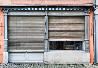 Altes geschlossenes Ladengeschäft mit heruntergelassenen Rolladen in einer Altstadt
