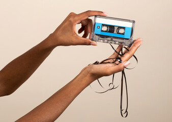 Faceless female showing retro cassette tape