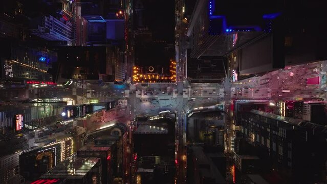 Aerial birds eye overhead top down view of colourful Times Square. Reflection of colours from advertisement displays. City at night from height. Manhattan, New York City, USA