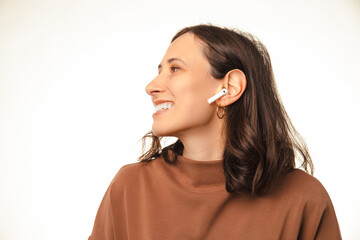 Close up shot of a wide smiling woman is wearing wireless headphones ear pods.