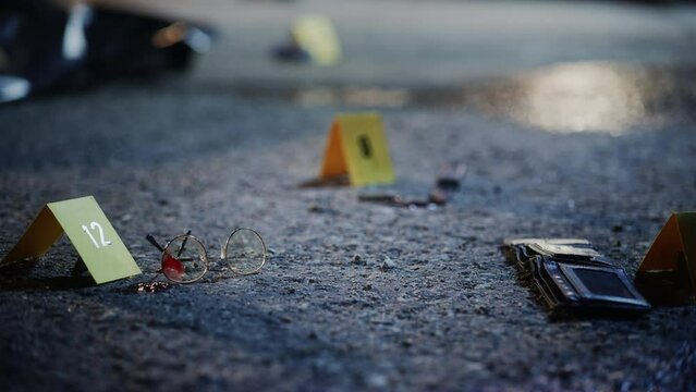 Close Up Low Angle Shot of Evidence Scattered in Crime Scene. Bloodied Glasses, Bloody Knife and Empty Wallet, all Marked as Clues in a Murder Investigation. True Crime Footage for Screen Replacement