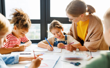 Teacher helping children with schoolwork