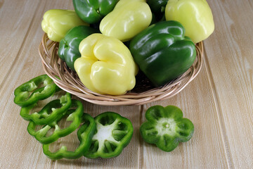 whole and chopped green peppers lie on the table for salad preparation