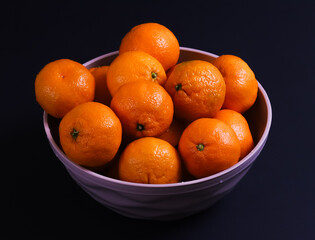 Ripe tangerines on a dark background. Close-up