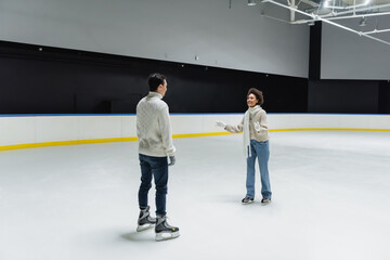 African american woman talking to boyfriend while skating on ice rink
