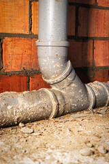 Sewer pipes in home basement. System of gray sanitary pipes when building a house. Sewer...