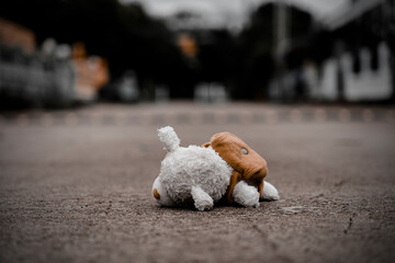 lonely teddy bear sleep on cement floor for created postcard  of international missing children, broken heart, lonely, sad, alone unwanted cute doll lost. - 550639738