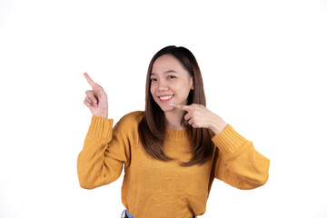 Young beautiful smiling good mood positive girl pointing finger in copyspace isolated on white background.