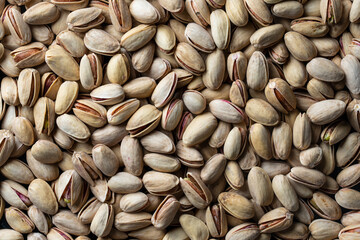 Pistachios texture and background. Pile pistachio kernels nuts with shell, closeup. Pistachio nuts. Whole nut kernels