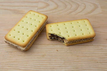 Cracker sandwiches with chocolate and cheese filling on wooden background