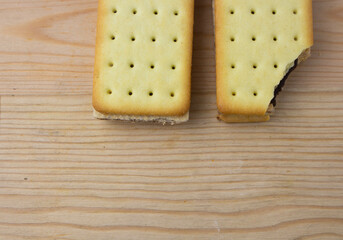 Cracker sandwiches with chocolate and cheese filling on wooden background
