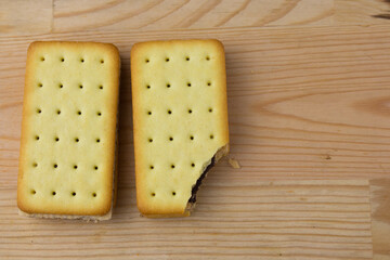 Cracker sandwiches with chocolate and cheese filling on wooden background