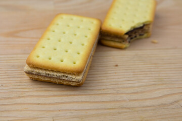 Cracker sandwiches with chocolate and cheese filling on wooden background