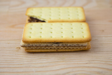 Cracker sandwiches with chocolate and cheese filling on wooden background