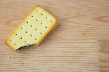 Cracker sandwiches with chocolate and cheese filling on wooden background