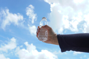 hand holding a small mineral water bottle