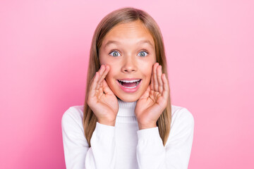 Portrait of positive astonished person arm near mouth say tell toothy smile isolated on pink color background