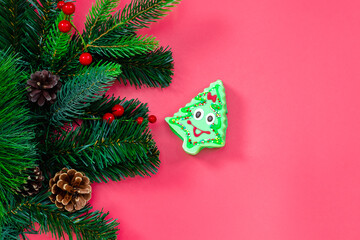 Banner with Christmas glazed gingerbread and Christmas tree branches on a pink background. Place for text on top. The concept of festive New Year's baking