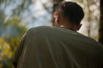 Back guy. Man in park. Close-up jacket. Man in back.