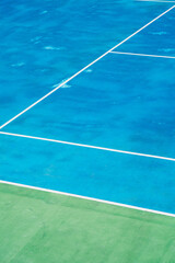 Deserted tennis court with greentrees in background in a public park on a sunny summer morning