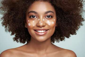 Beauty portrait of African girl with snowflakes her face. Beautiful black woman. Cosmetics, makeup...