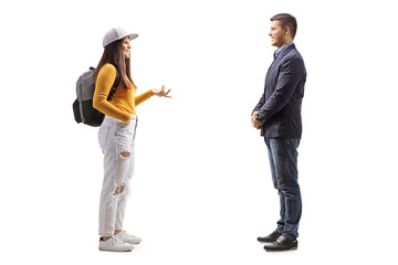 Full length profile shot of a female student with a backpack  talking to a man