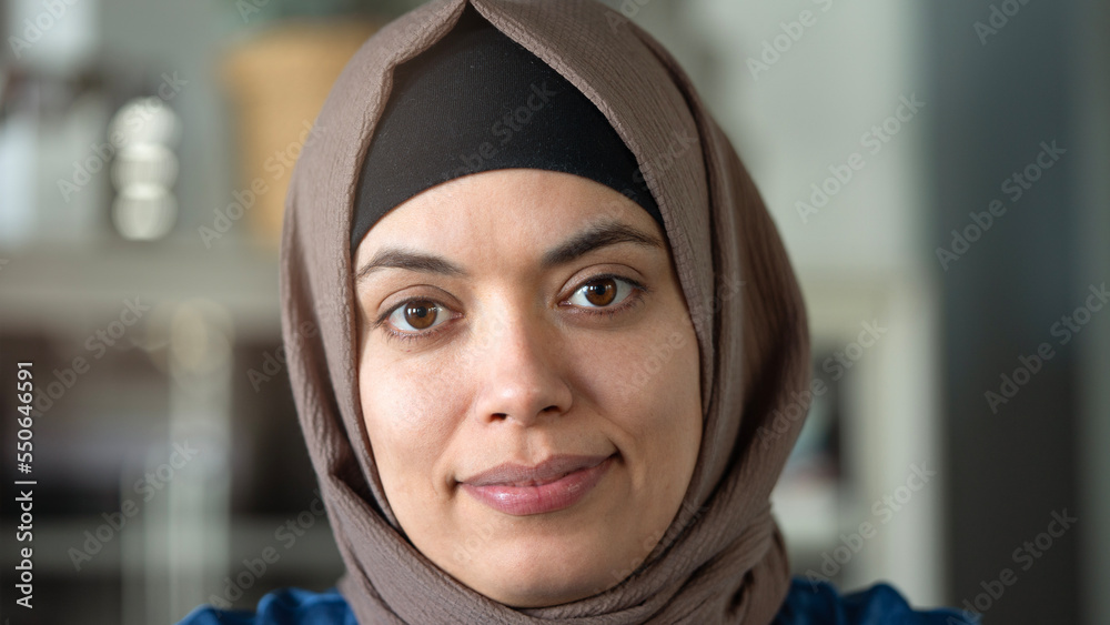 Wall mural woman looking at camera and wearing a hijab