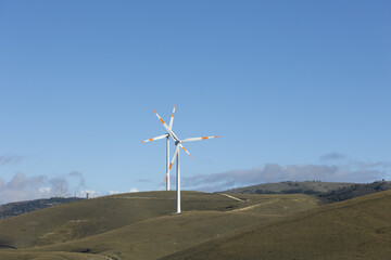 a wind farm full of turbines in the Italian mountains. The green economy and technology are the only solution to protect the planet from climate change and global warming