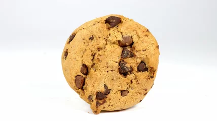 Keuken foto achterwand Closeup of a circular American chocolate chip cookie placed upright on a white background © Giuseppe Silvestri/Wirestock Creators