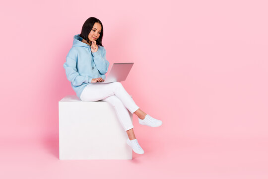 Photo of concentrated focused intelligent lady sit white podium hand touch chin write email empty space isolated on pink color background