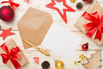 Craft envelope with christmas decoration on wooden background, top view