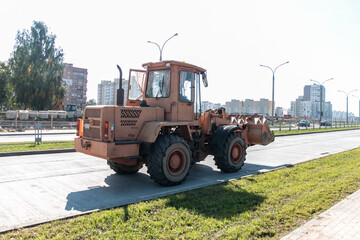 A wheeled bulldozer is conducting road construction work in the city.