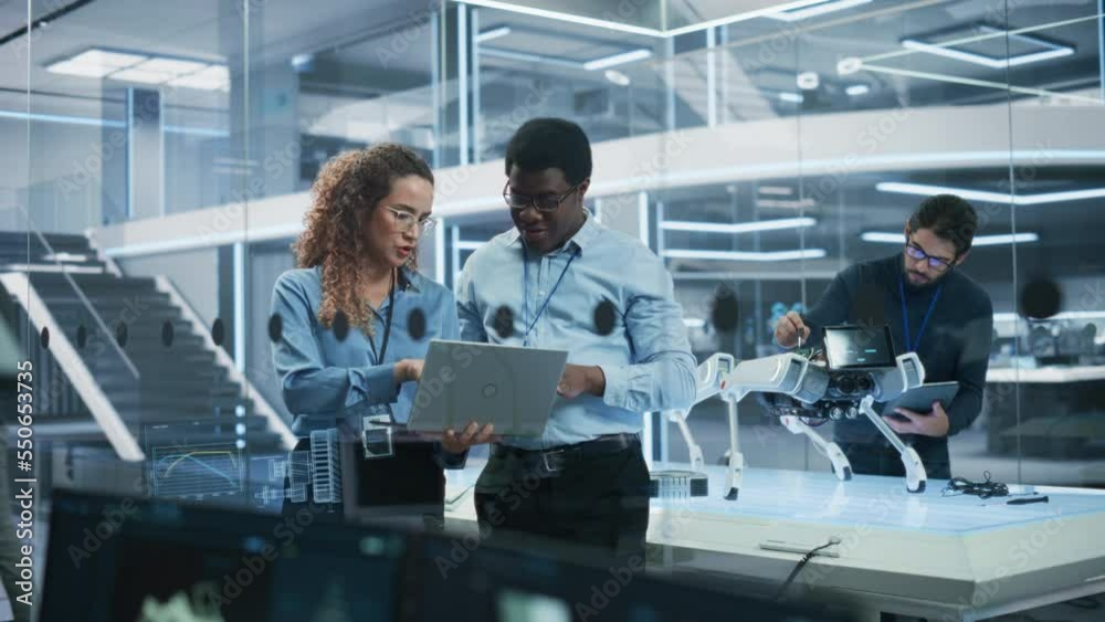 Poster Portrait of Two Multiethnic Female and Male Engineers Use Laptop Computer to Connect, Analyze and Discuss How to Program a Robot Dog. Standing in High Tech Research Laboratory with Modern Equipment.