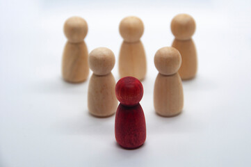 Red figure leading other wooden figure with white background. Leadership concept