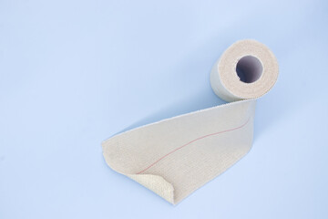 Elastic adhesive bandage on blue background, strong and stretchy