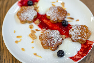 White plate with breakfast on the table; 
cheesecakes with sour cream jam