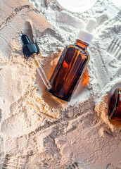 Natural cosmetics face oil in brown bottle on the sand