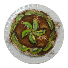 homemade layered cake with cream, chocolate and kiwi slices on a white platter